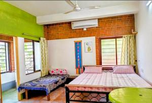 a bedroom with two beds and a brick wall at Yangzom Homez in Siliguri