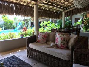 a wicker couch on a porch with a view of a pool at Casa Cauipe Cumbuco in Paracumbuca