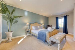 a bedroom with a bed and a potted plant at Stunning 4 Bedroom Farmhouse in Bishopton