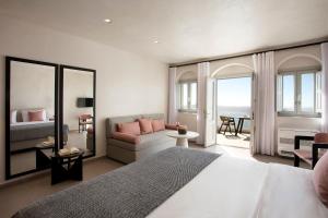una camera da letto con un letto grande e un soggiorno di Andromeda Villas & Spa Resort a Imerovigli