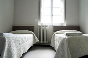 a room with two beds and a window at Albergue Capuchinos Rocamador in Estella