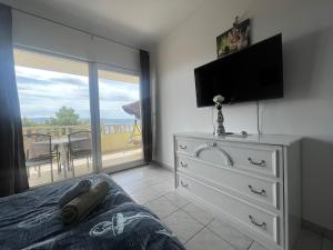 Un dormitorio con una cama y una cómoda con televisión. en Apartments Zemunik, en Omiš