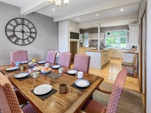 a dining room table with chairs and a clock on the wall at Redway Lodge in Porlock