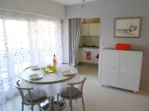 a kitchen with a table with chairs and a refrigerator at Bel appartement lumineux avec balcon, proche des Thermes et commerces, animaux admis - FR-1-503-62 in Balaruc-les-Bains