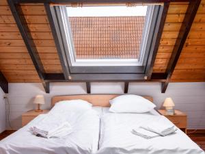 ein Schlafzimmer mit einem Bett mit weißen Laken und einem Fenster in der Unterkunft Holiday Home Koralle-1 by Interhome in Norddeich