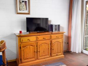einen Fernseher auf einer hölzernen Kommode in der Unterkunft Holiday Home Koralle-1 by Interhome in Norddeich