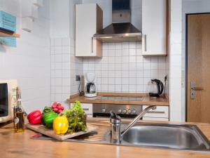 eine Küche mit Spüle und Gemüse auf einem Schneidebrett in der Unterkunft Holiday Home Koralle-1 by Interhome in Norddeich