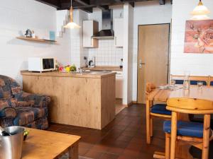 eine Küche und ein Wohnzimmer mit einem Tisch und einem Sofa in der Unterkunft Holiday Home Koralle-1 by Interhome in Norddeich + 29 Fotos