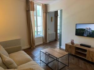 a living room with a couch and a flat screen tv at Hyper centre st Germain en laye appt de standing in Saint-Germain-en-Laye