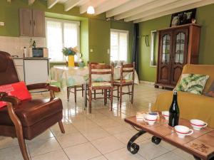 a living room with a table and chairs and a bottle of wine at Holiday Home L'Egven by Interhome in Matignon