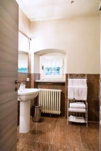 a bathroom with a sink and a mirror and a radiator at B&B Dimora Delle Donnole Bergamo Alta in Bergamo