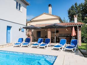 a group of chairs and umbrellas next to a swimming pool at Holiday Home Mariva by Interhome in Potpićan