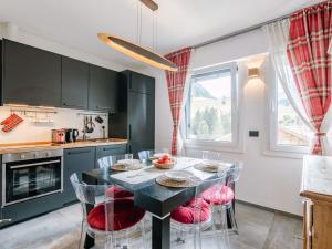 a kitchen with a table and chairs in a kitchen at Apartment Family House by Interhome in Moena