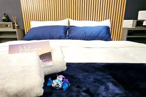 un letto con lenzuola bianche e cuscini blu sopra di Herolds Bay 510 a Herolds Bay