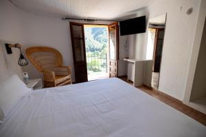a bedroom with a large white bed and a window at Moli l'Abad in Puebla de Benifasar
