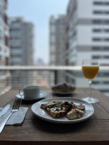 a plate of food and a glass of wine on a table at Habitarte Brooklin in Sao Paulo