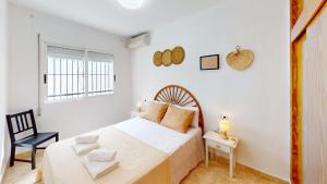 Un dormitorio blanco con una cama y una silla. en Holidoo Casa Marbella, en Los Alcázares