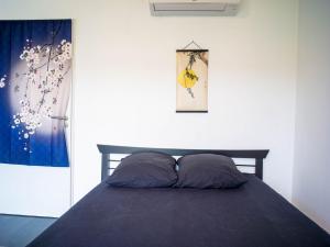 a bed with two pillows in a bedroom at Kitsuné Lodge zen d'inspiration japonaise in Chaintré