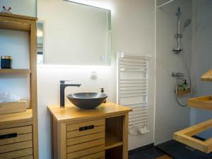 a bathroom with a bowl sink on a wooden vanity at Kitsuné Lodge zen d'inspiration japonaise in Chaintré