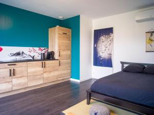 a bedroom with a bed and a blue wall at Kitsuné Lodge zen d'inspiration japonaise in Chaintré