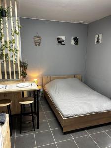 una camera da letto con un letto, un tavolo e una scrivania di studio2 a Vins-sur-Caramy