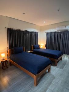 two beds in a room with black curtains at BSK Bungalows in Lipa Noi +67 photos