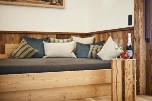 a bed with blue and white pillows on it at Dreisessel-Chalets im bayerischen Wald - Chalet Hochstein - mit Whirlpool-Sauna-Kamin in Haidmühle
