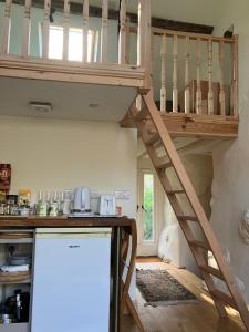 Cama elevada en una cocina con escalera en Studio in medieval Welsh farmhouse, en Aber Cowarch 3 fotos más