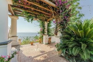 a pergola with flowers and plants on a patio at Mareluna in Procida