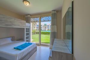 a bedroom with a bunk bed and a large window at Elegant apartment with pool and beach access in Hurghada