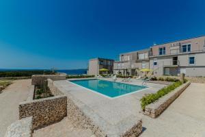 a swimming pool in front of a building at Sea Around in Povljana