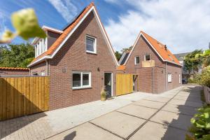 a brick house with a wooden fence on a street at Vakantiehuis DO57 centrum Domburg in Domburg