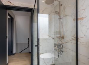 a bathroom with a shower with a glass door at Vakantiehuis DO57 centrum Domburg in Domburg +17 photos