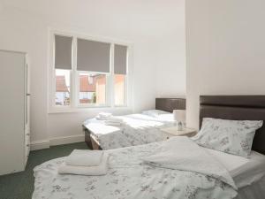 a bedroom with two beds and a window at Wave from it All in Llandudno