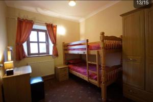 a bedroom with two bunk beds and a window at Aberystwyth Enlli Cottage in Llanilar