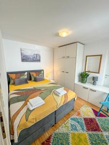 een slaapkamer met een groot bed en een blauwe stoel bij Apartman Mi-Bel in Zagreb