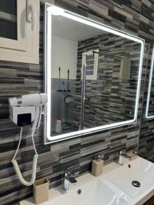 a bathroom with a sink with a large mirror at Charmante maison avec jacuzzi in Le Gosier
