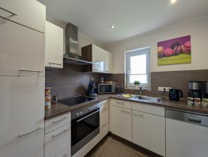 a kitchen with white cabinets and a sink at Ferienhaus Ostara in Hasselfelde