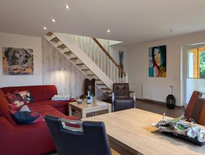 a living room with a red couch and a table at Ferienhaus Ostara in Hasselfelde +30 photos