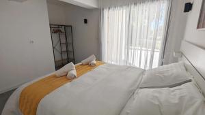 a bedroom with a large white bed with towels on it at Maison Neuve en Provence in Lambesc