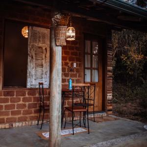 a table and chairs on a porch of a brick house at Villa Vinil in Bichinho