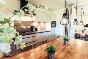 a kitchen with a wooden table with plants on it at Veluwe Vallei 16-person bungalow in Voorthuizen