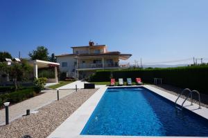 a villa with a swimming pool in front of a house at Pooltugal House in São Romão