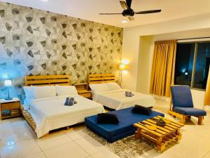 ein Schlafzimmer mit zwei Betten und einer Couch und Stühlen in der Unterkunft Near Sunway Damen Cozy Homestay in Subang Jaya