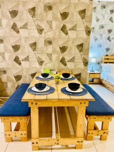 einem Holztisch mit Schalen und Platten darauf in der Unterkunft Near Sunway Damen Cozy Homestay in Subang Jaya