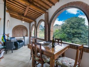 a dining room with arched windows and a table and chairs at Holiday Home Podere Palazzetto by Interhome in Buonconvento