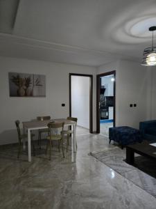 a living room with a table and chairs and a couch at Luxury apartment in Ariana