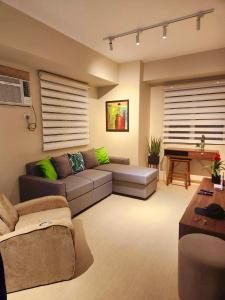 Una sala de estar con un sofá y un piano. en One Bedroom Condominium Avida Tower 1 Aspira CDO, en Cagayan de Oro