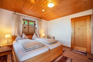 a bedroom with two beds and a wooden ceiling at Allpano in Dietmannsried