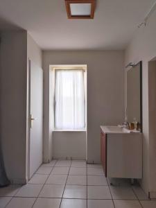 ein leeres Badezimmer mit Waschbecken und Fenster in der Unterkunft La maison de l'Architecte - Gite proche Bordeaux in Salleboeuf